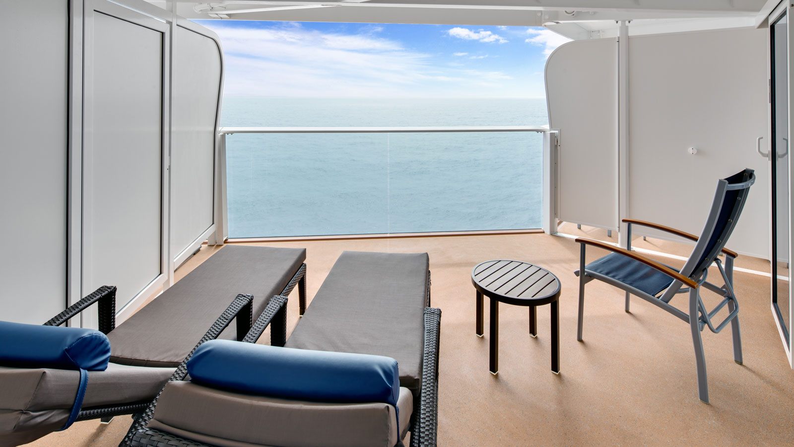 Two chairs in the balcony overlooking pristine ocean views.