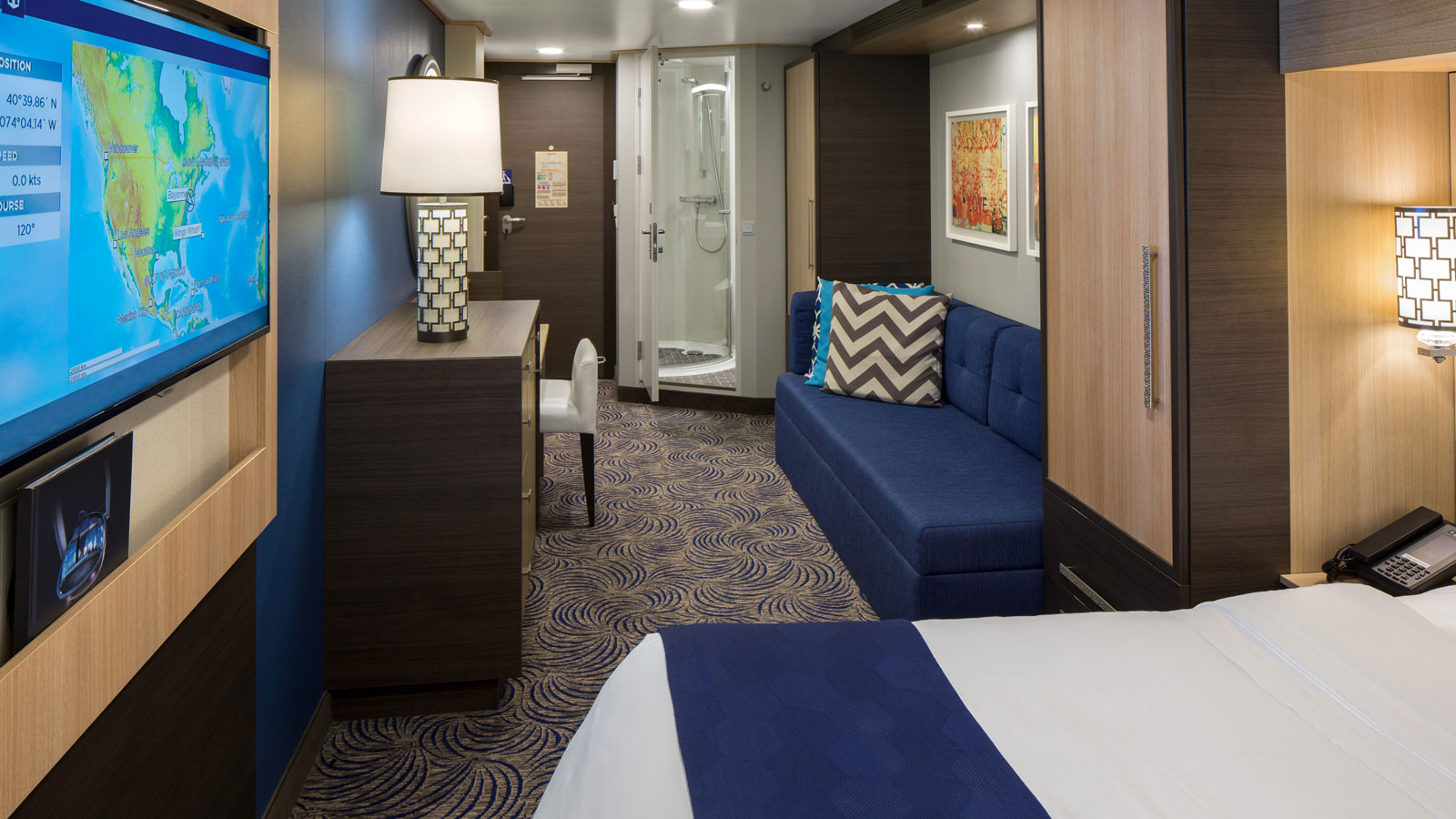 The bed, television and stateroom entrance of the Ocean View Balcony