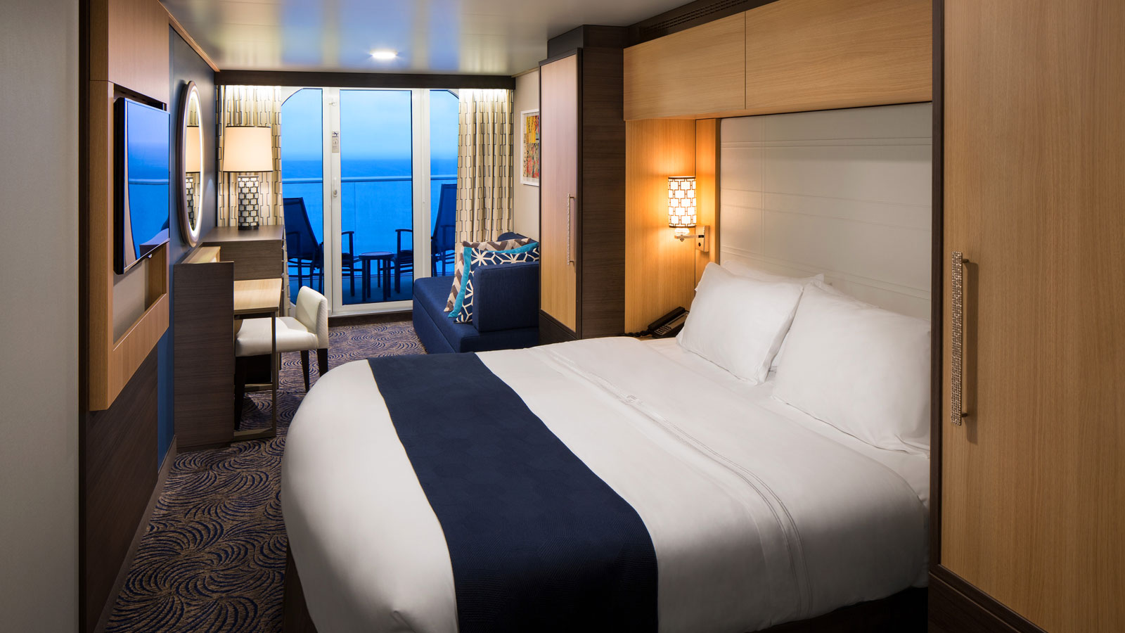 Main view of the Ocean View with Large Balcony stateroom with vanity, sofa, bed, and balcony.
