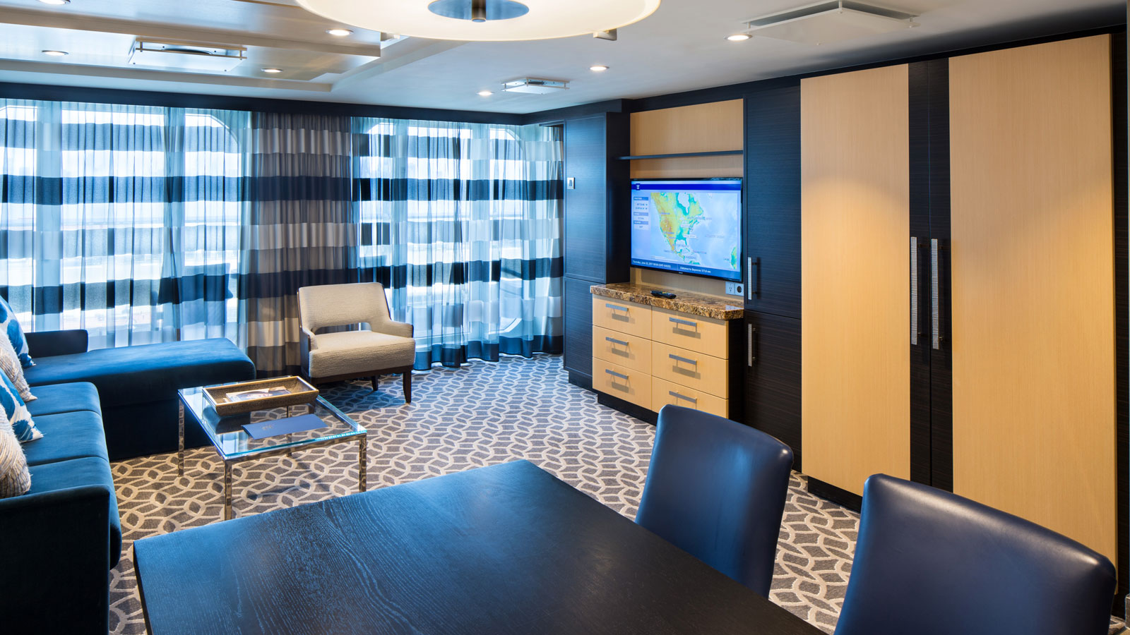 Living room view including sofa, side chairs, coffee table and large television
