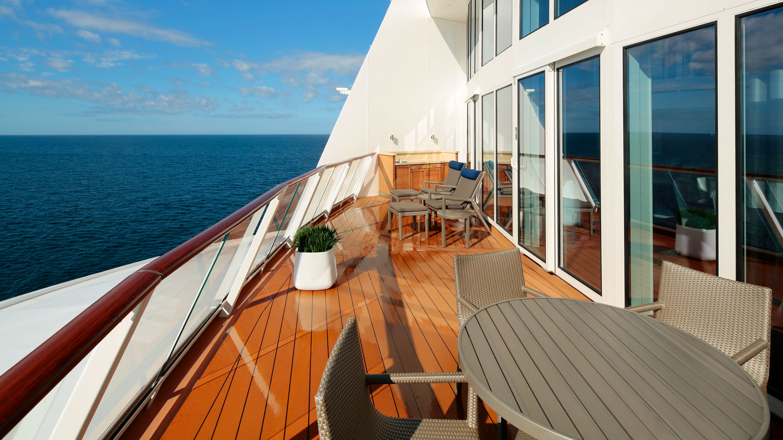 A table and chairs set up on the balcony overlooking the stunning ocean views