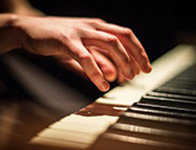 Hands playing the piano as part of the wedding entertainment services.