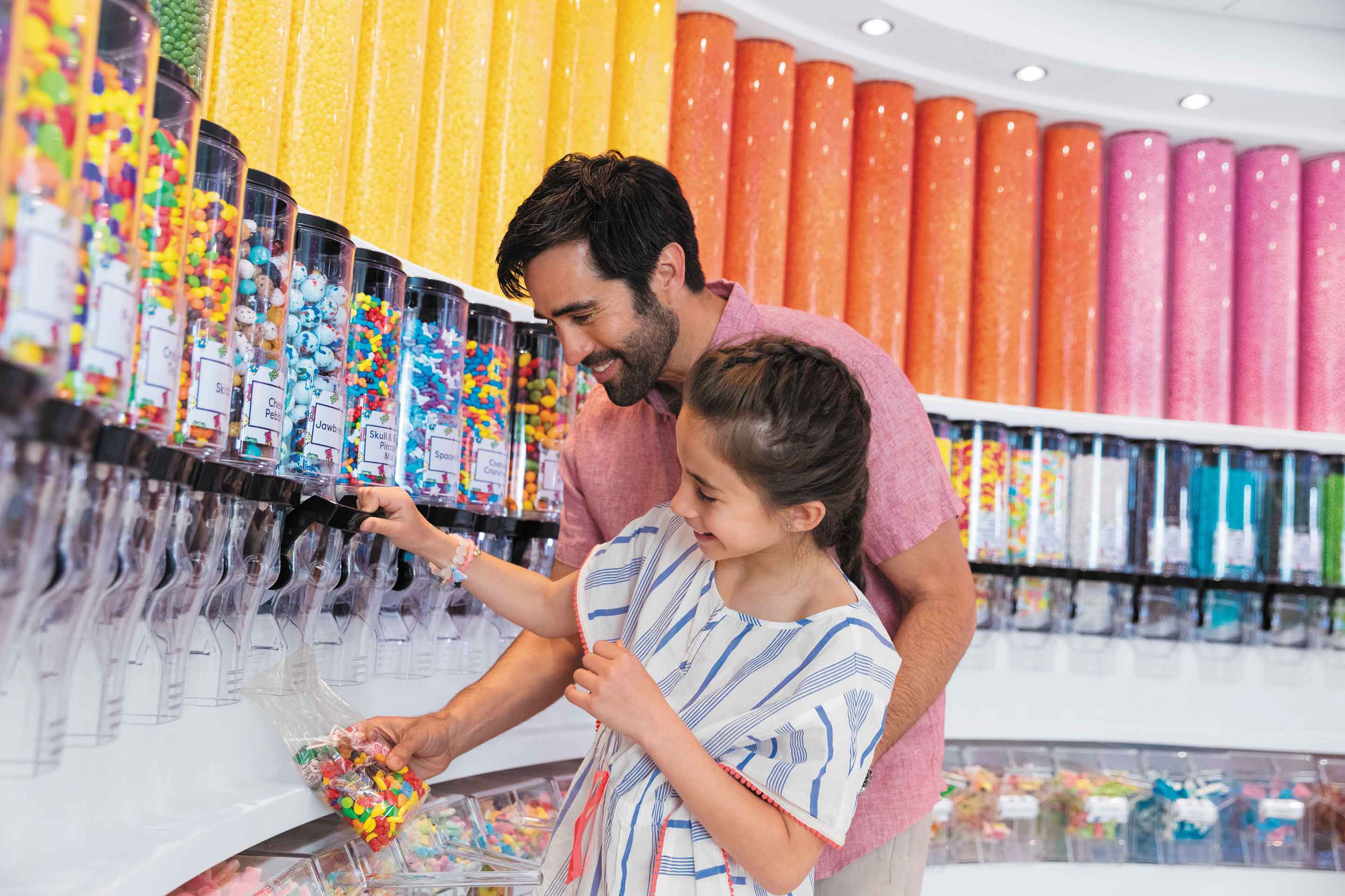 Padre e hija vertiendo dulces en las bolsas en la tienda de caramelos a bordo, Sugar Beach