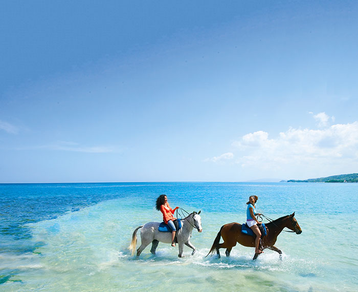 Horseback riding in the clear water of the beach in Falmouth, Jamaica