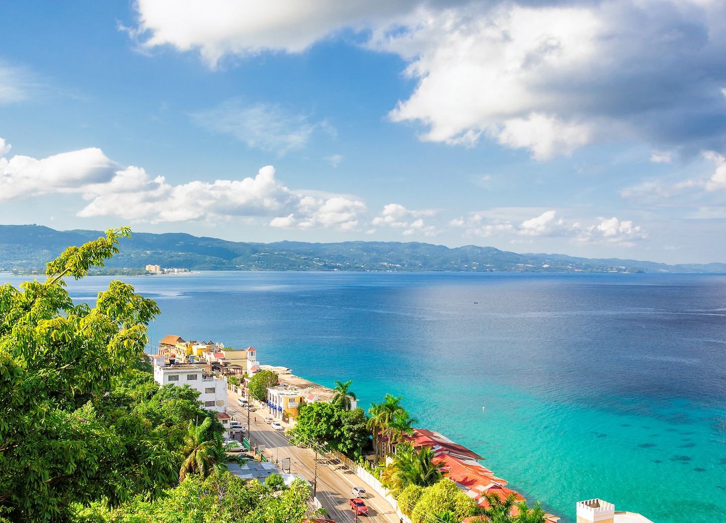 Montego Bay’s port sits along bright turquoise water, backed by green hills and a sunny coastline. - Falmouth, Jamaica