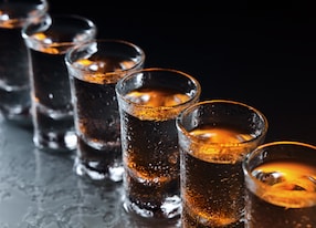 glasses with an alcoholic drink on a damp glass table alcohol