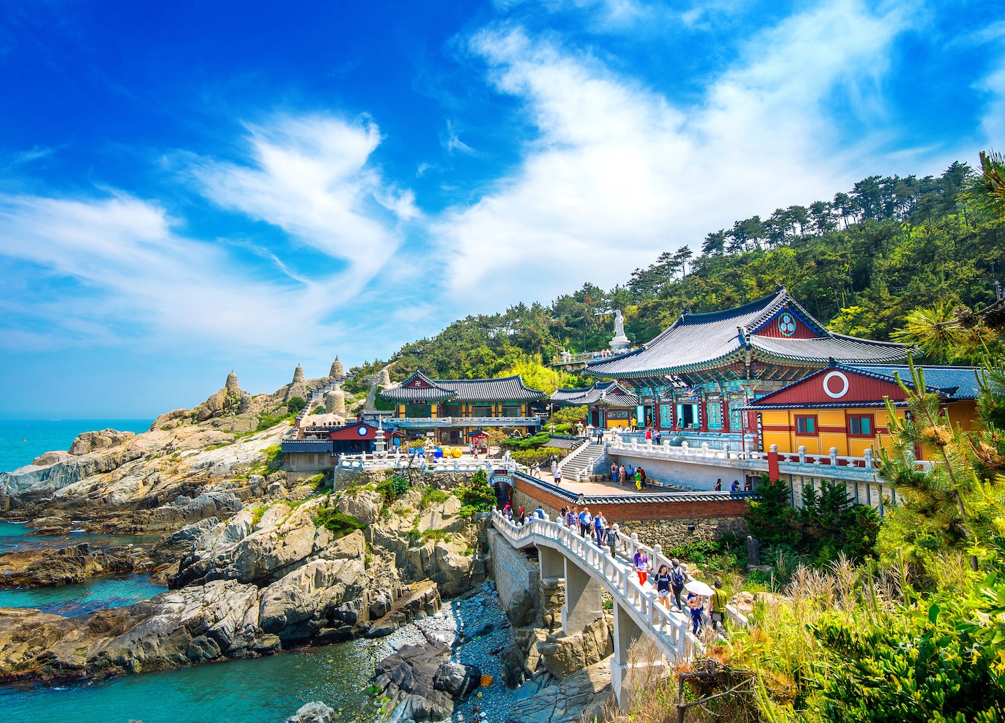 Haedong Yonggungsa Temple sits on rocky seaside cliffs, overlooking waves along Busan’s coastline. - Busan, South Korea