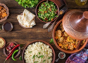 traditional tajine dishes couscous and fresh salad on rustic wooden table tagine lamb meat and