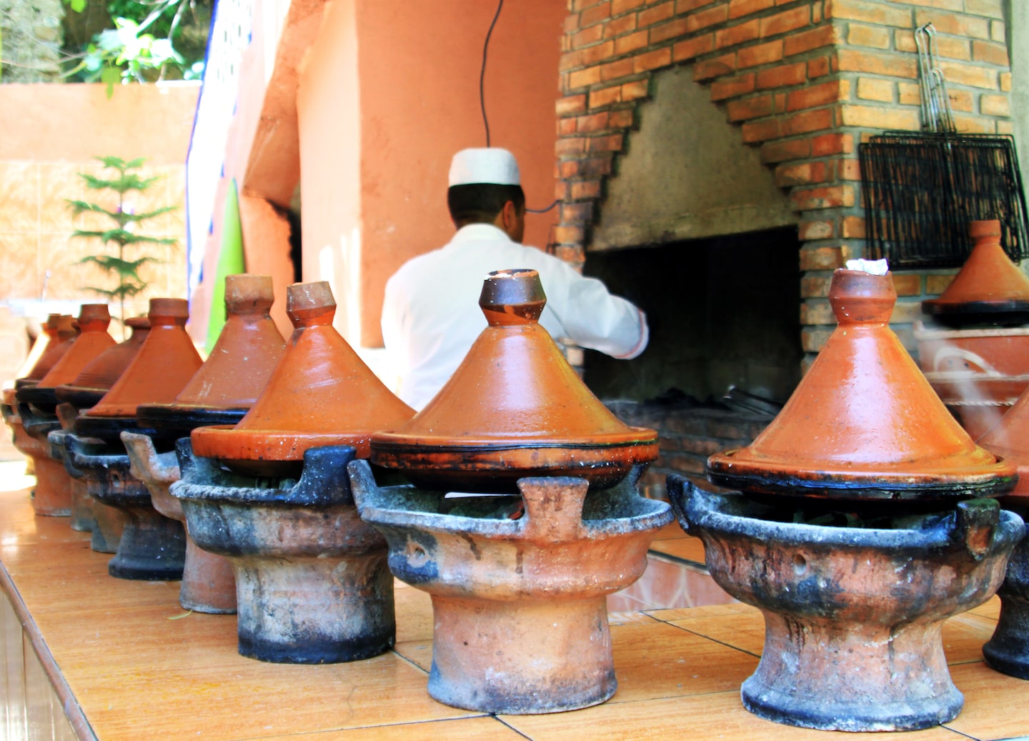 Colorful Moroccan ceramic tajines sit stacked together, showcasing traditional handcrafted cookware and patterns. - Morocco 