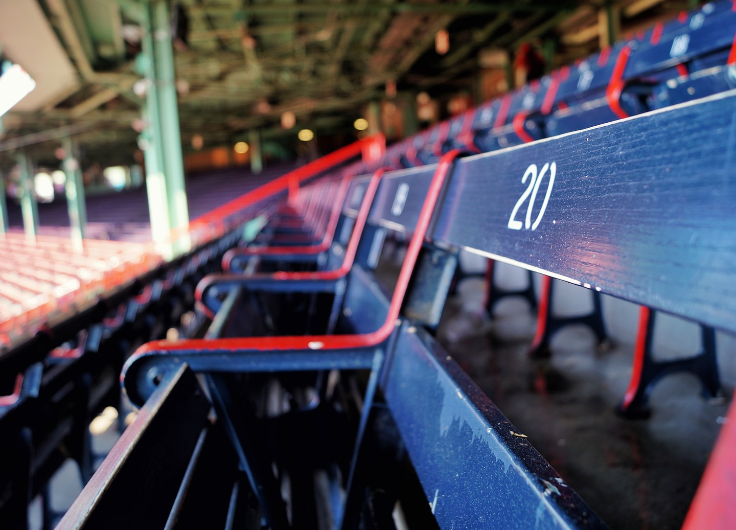 Old wooden bleacher seats at Fenway Park show worn paint and classic ballpark charm. - Boston, Massachusetts