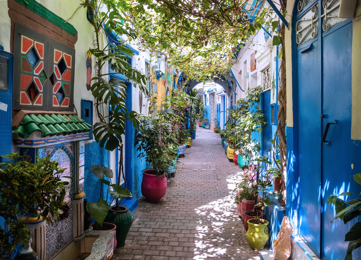 A quiet Tangier Kasbah street lined with whitewashed walls and archways under soft afternoon light. - Tangier, Morocco