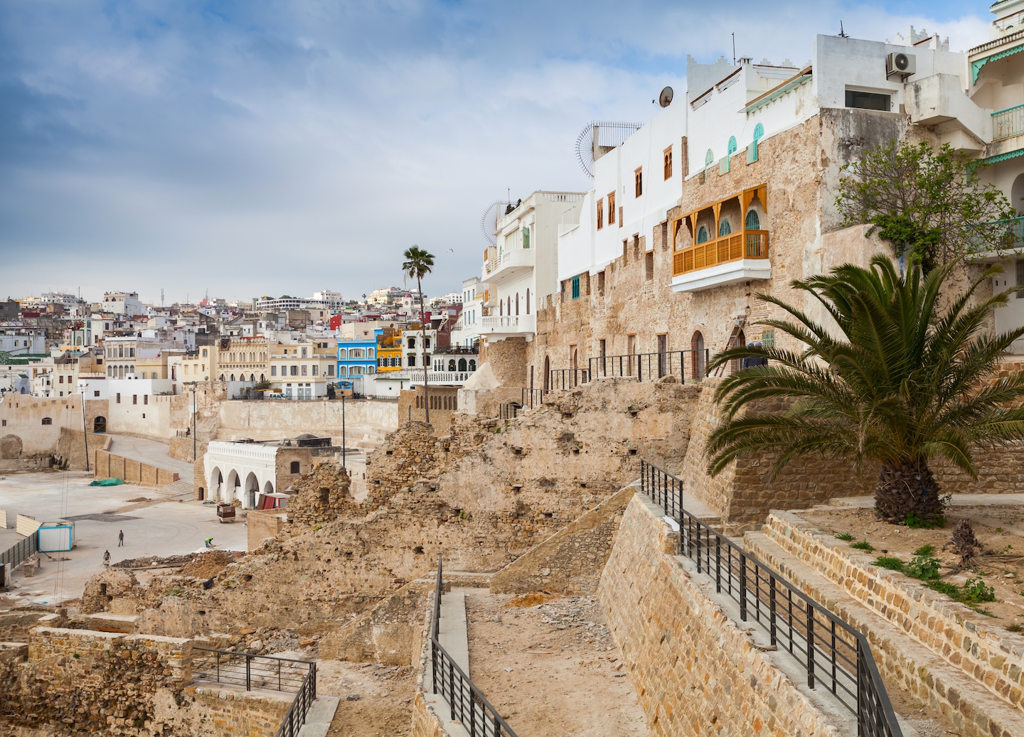 Ancient stone walls of Tangier’s medina rise above narrow streets under warm North African light. - Tangier, Morocco