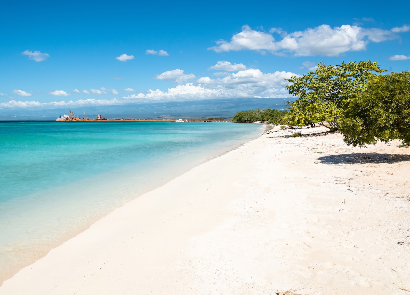 A quiet Cabo Rojo beach shows soft sand, turquoise water, and gentle waves under a bright sky. - Cabo Rojo, Dominican Republic