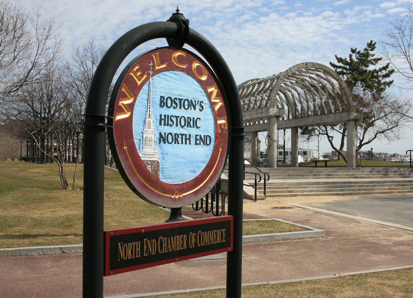 An arching “North End” entrance sign stands above the street, marking Boston’s historic neighborhood. - Boston, Massachusetts