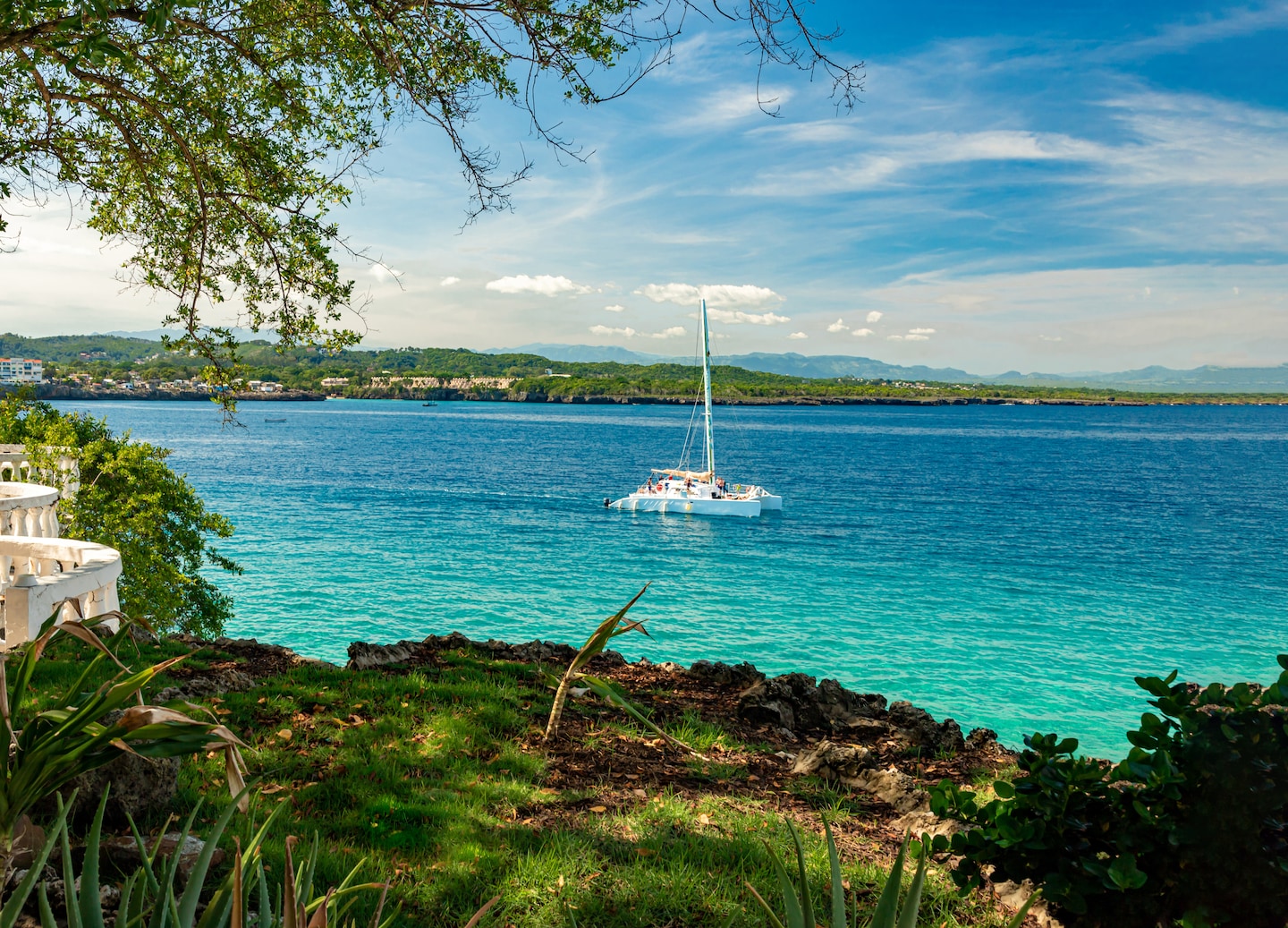 A catamaran glides across bright blue water near Puerto Plata. - Puerto Plata, Dominican Republic
