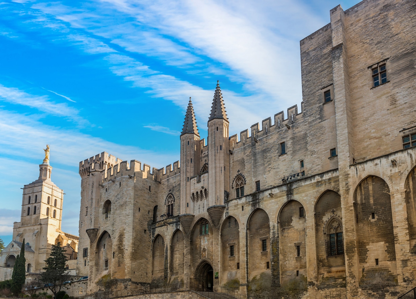 The Palace of the Popes towers over Avignon, its fortified stone walls dominating the historic square.  - Provence (Marseille), France