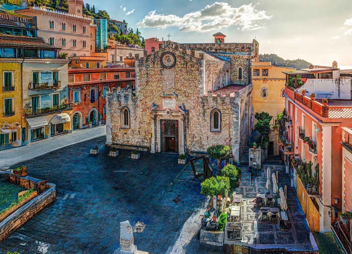Taormina’s Duomo stands above the hillside town, framed by warm Sicilian light and coastal views. - Sicily (Messina), Italy
