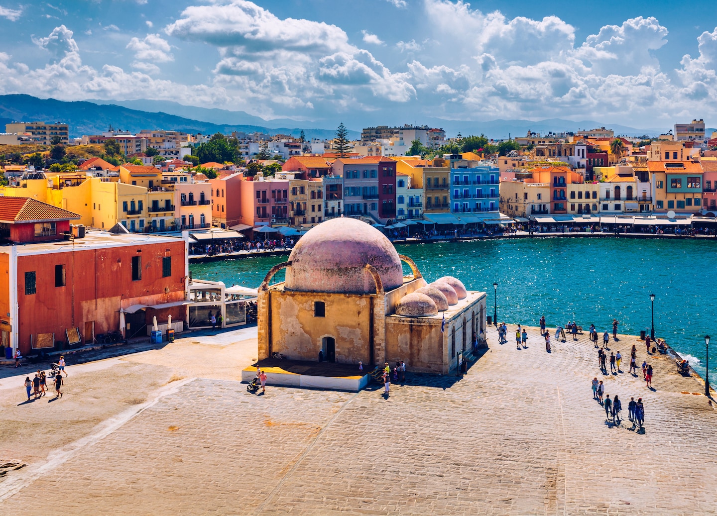 Aerial view of Chania’s Venetian Harbor shows its mosque and waterfront glowing in soft sunlight. - Chania, Crete