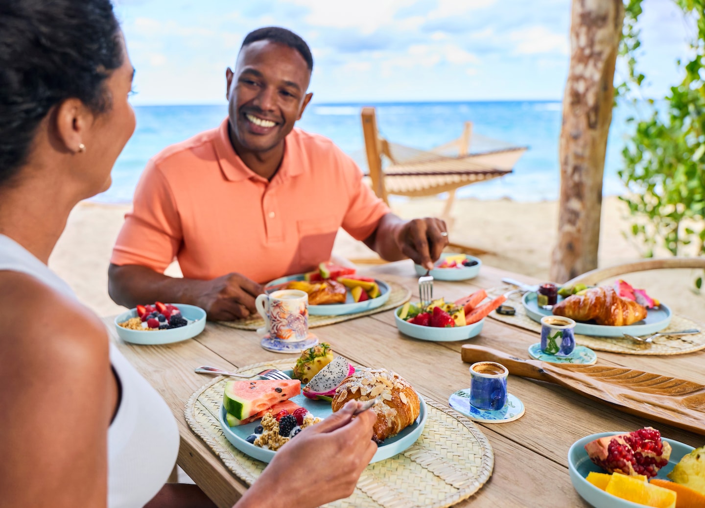A family enjoys breakfast in a beachfront cabana, overlooking calm blue water at Chill Beach. - Royal Beach Club, Nassau, Bahamas
