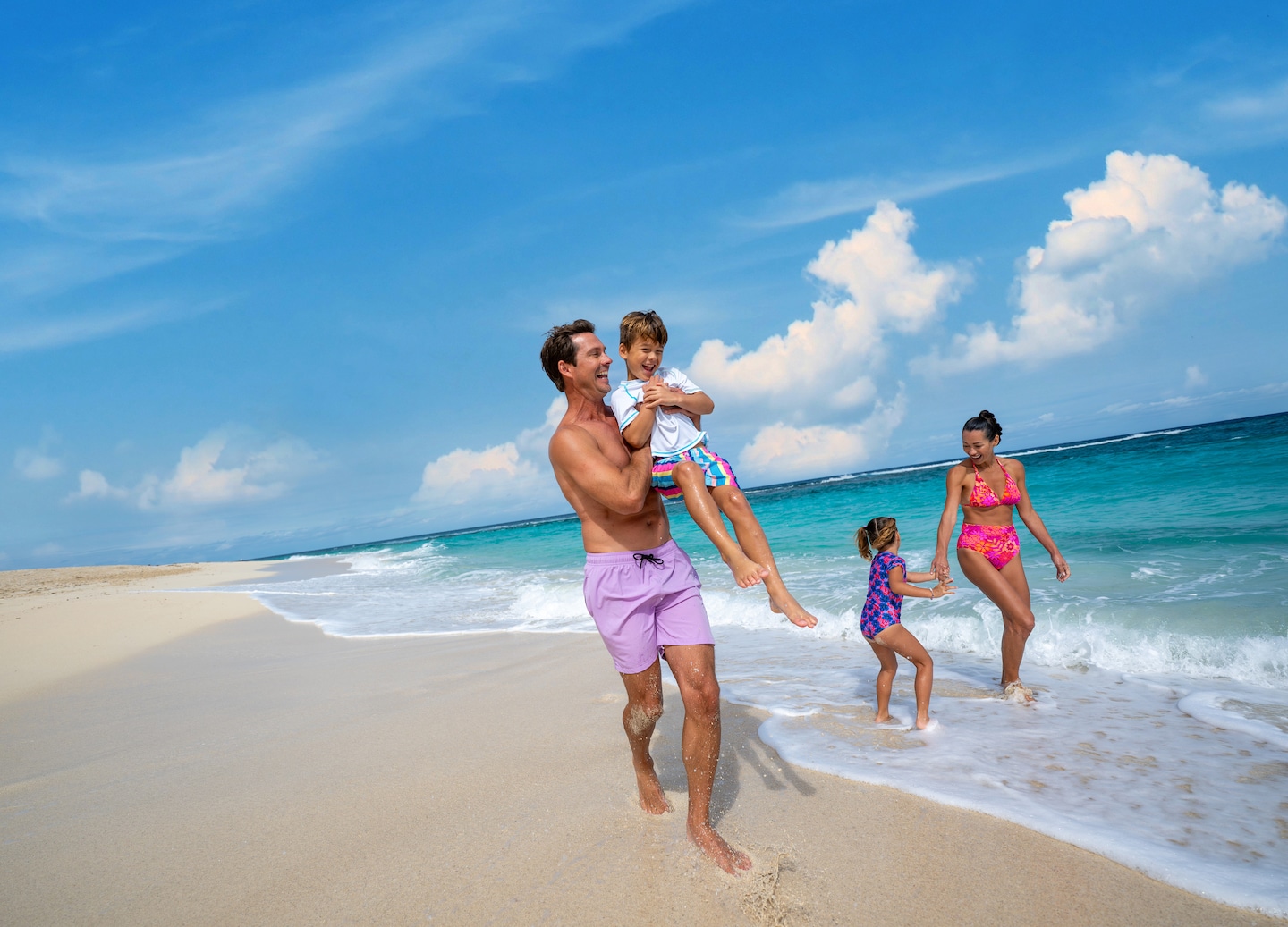 Sun loungers line a quiet beach as gentle turquoise waves meet soft white sand. - Bahamas
