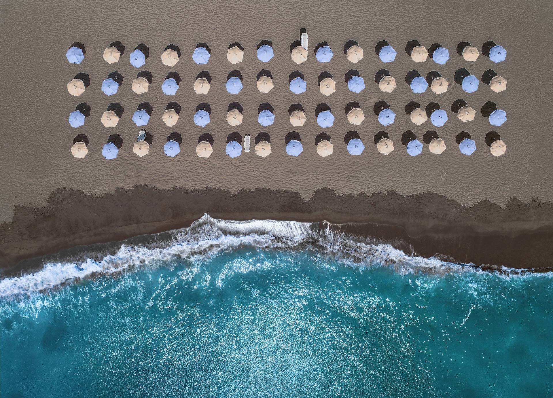 royal beach club santorini aerial top down beach umbrellas