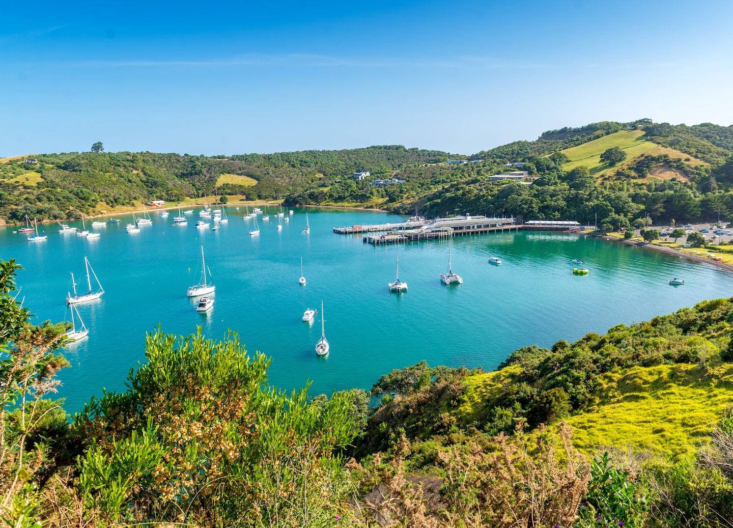Waiheke Island and anchored boats in a turquoise bay. - Auckland, New Zealand