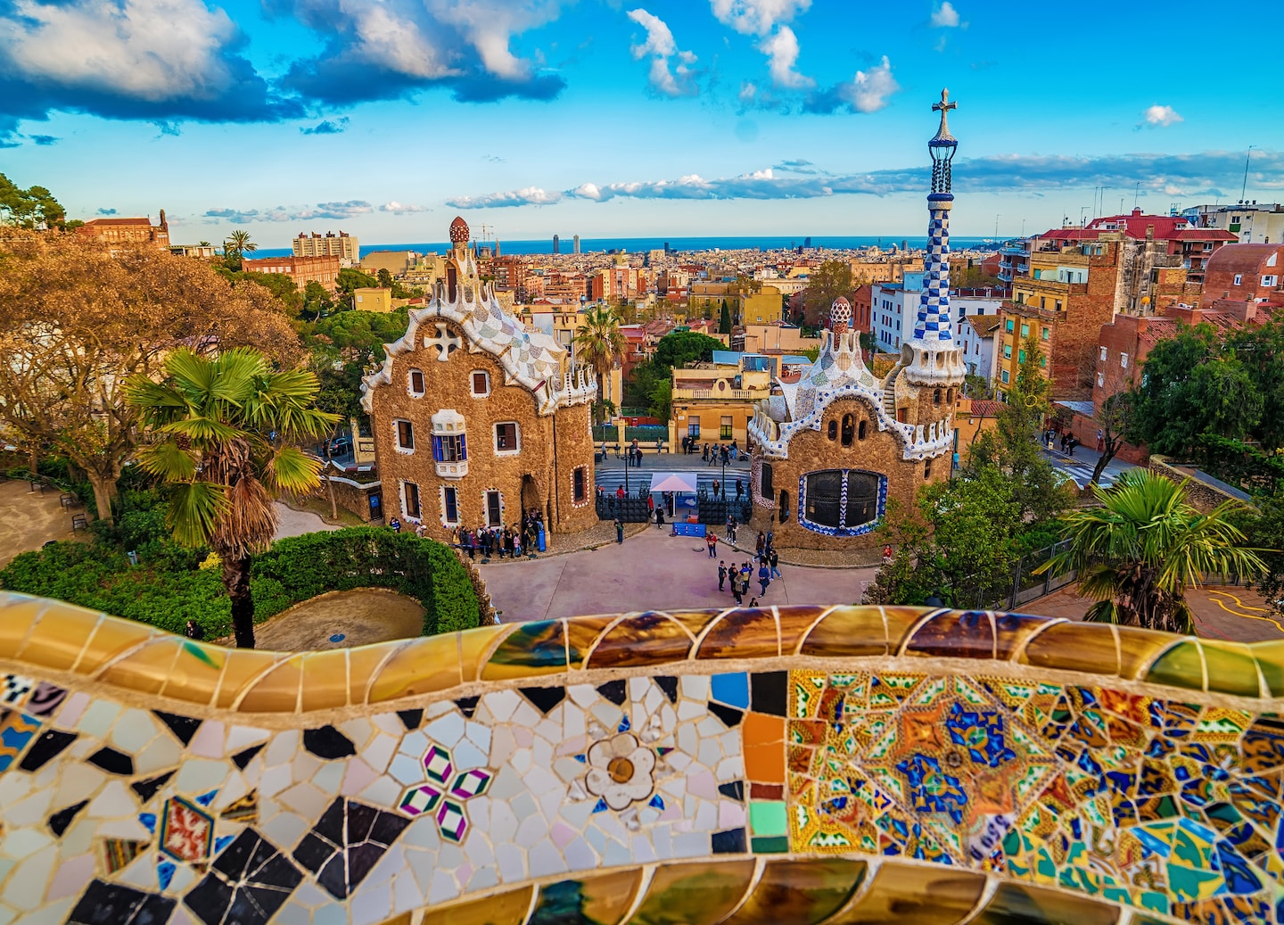 Park Güell’s whimsical Gaudí buildings glow at sunset, overlooking Barcelona’s colorful cityscape. - Barcelona, Spain