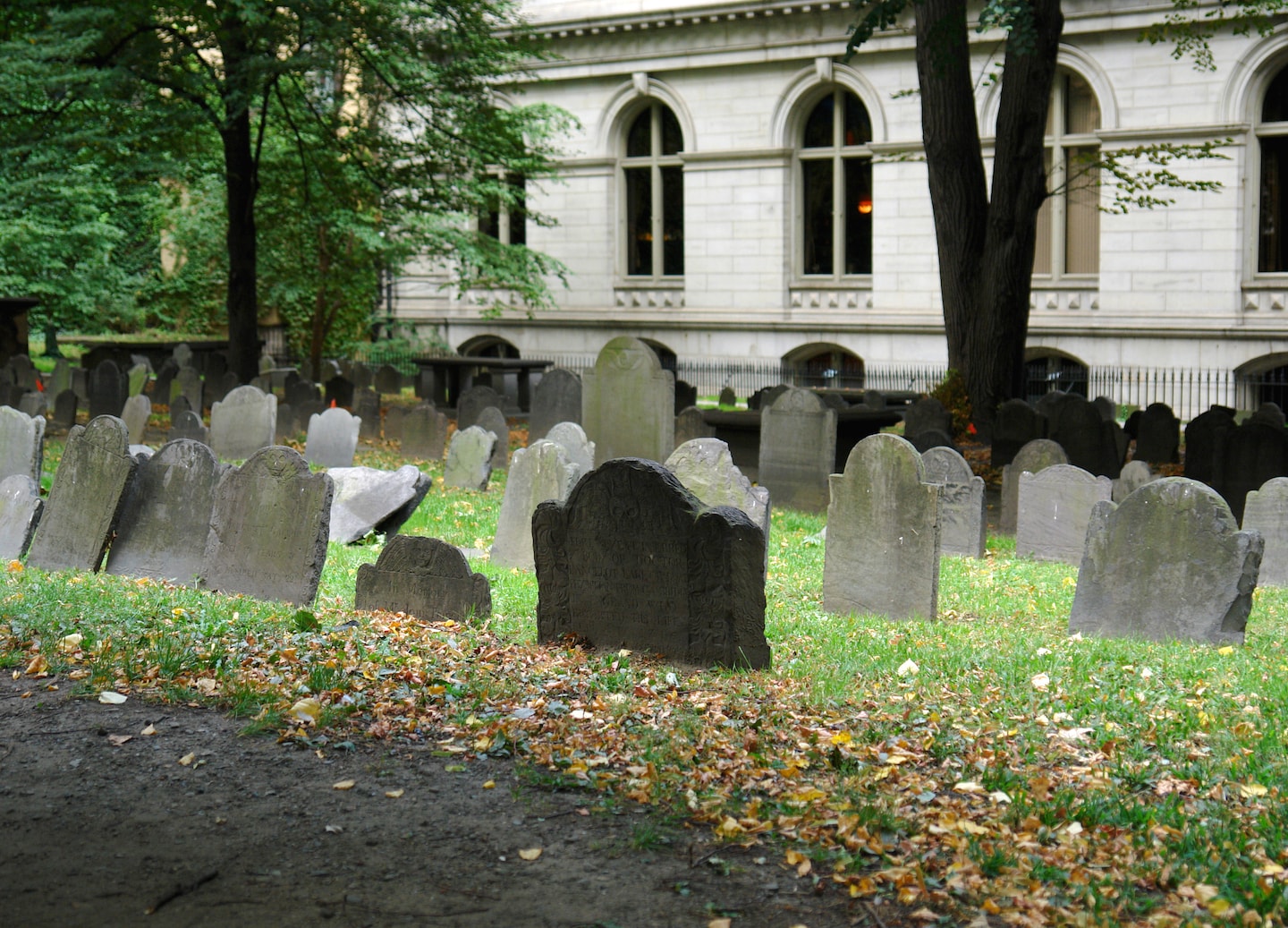 Historic King’s Chapel Burying Ground shows old gravestones surrounded by trees. - Boston, Massachusetts