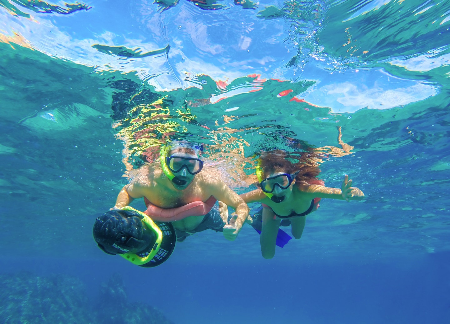 A couple power‑snorkels through clear Sea of Cortez water. - Cabo San Lucas, Mexico
