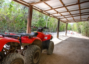 red atv parked on sandy dirt road