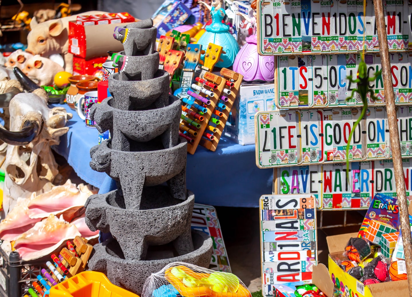 Colorful street stall displays woven blankets, hats, and souvenirs. - La Paz, Mexico