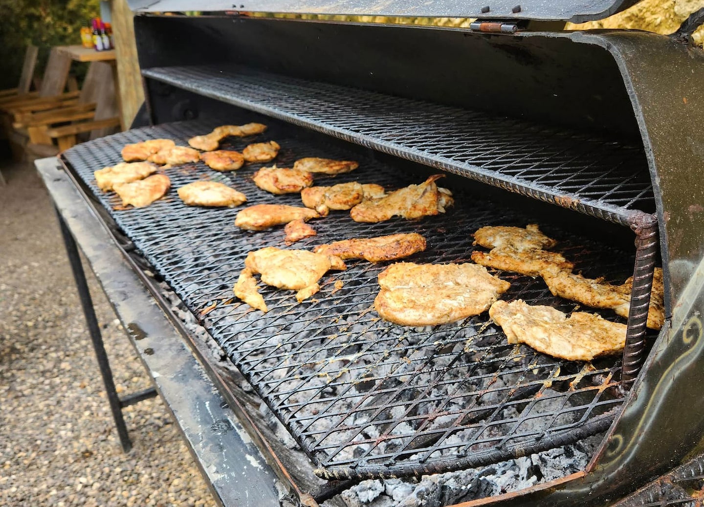 Jerk chicken sizzles on the grill, its charred edges showing rich Jamaican seasoning. - Jamaica