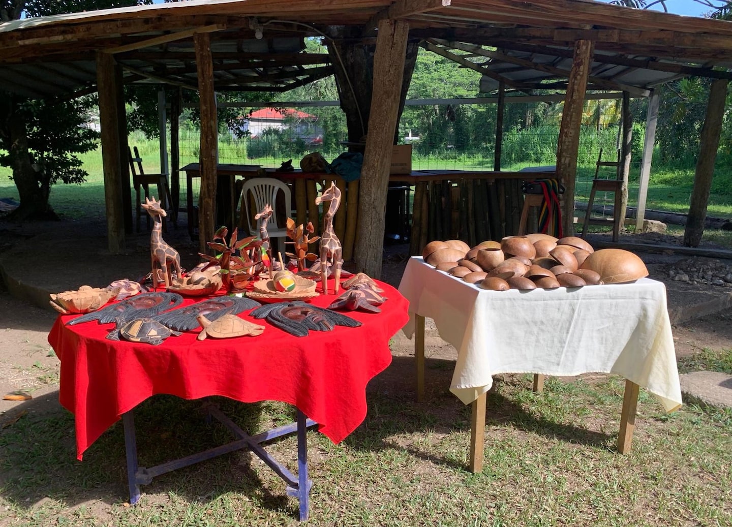 Carved wooden statues stand together, highlighting Rastafarian artistry and cultural symbolism in the village. - Falmouth, Jamaica