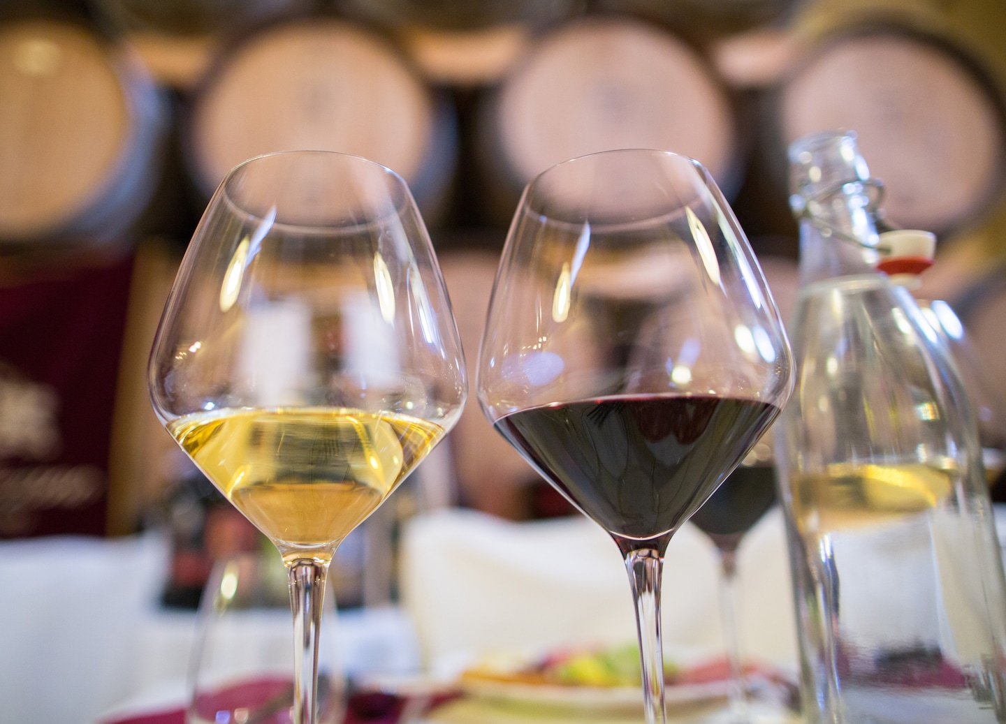 Two glasses of wine sit ready for tasting inside a warm, rustic Tuscan farmhouse. - Tuscany, Italy
