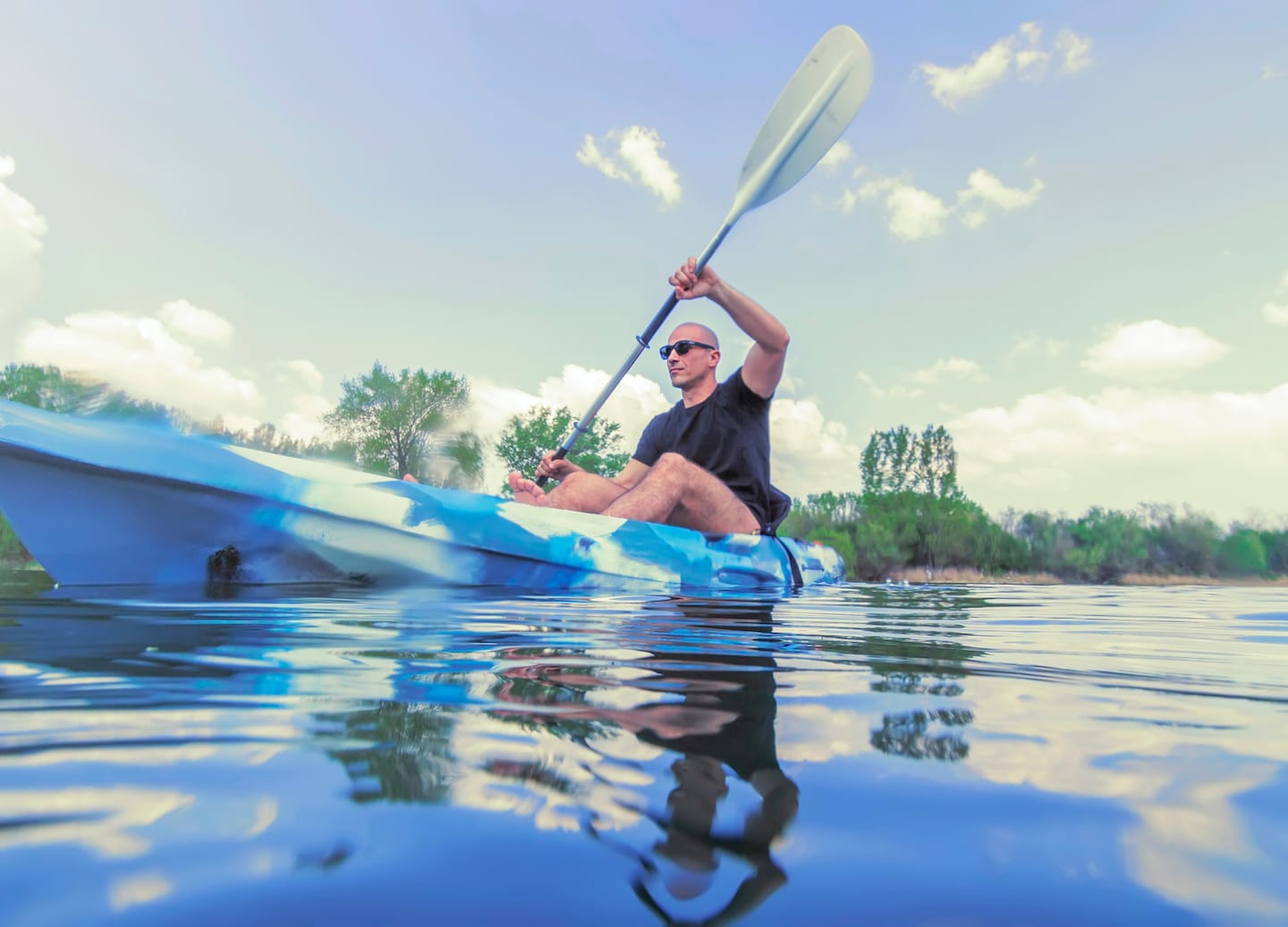 Man kayaking across calm water surrounded by green mangroves. - Fort-de-France, Martinique