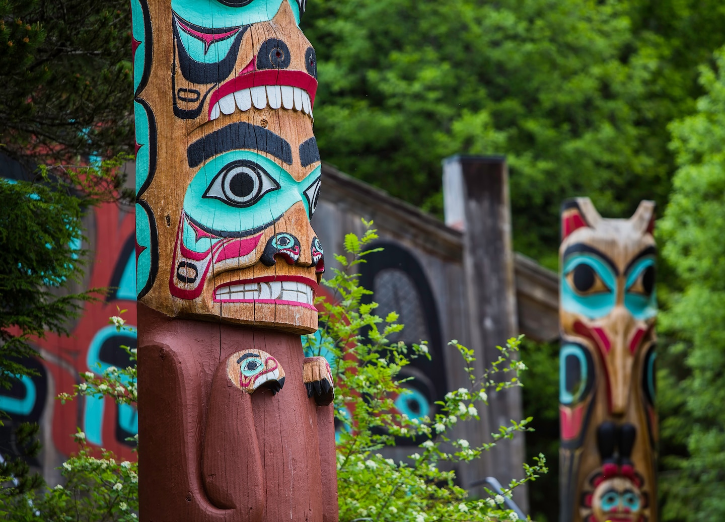 Carved Tlingit totem pole featuring colorful figures and traditional Indigenous cultural artwork. - Haines, Alaska
