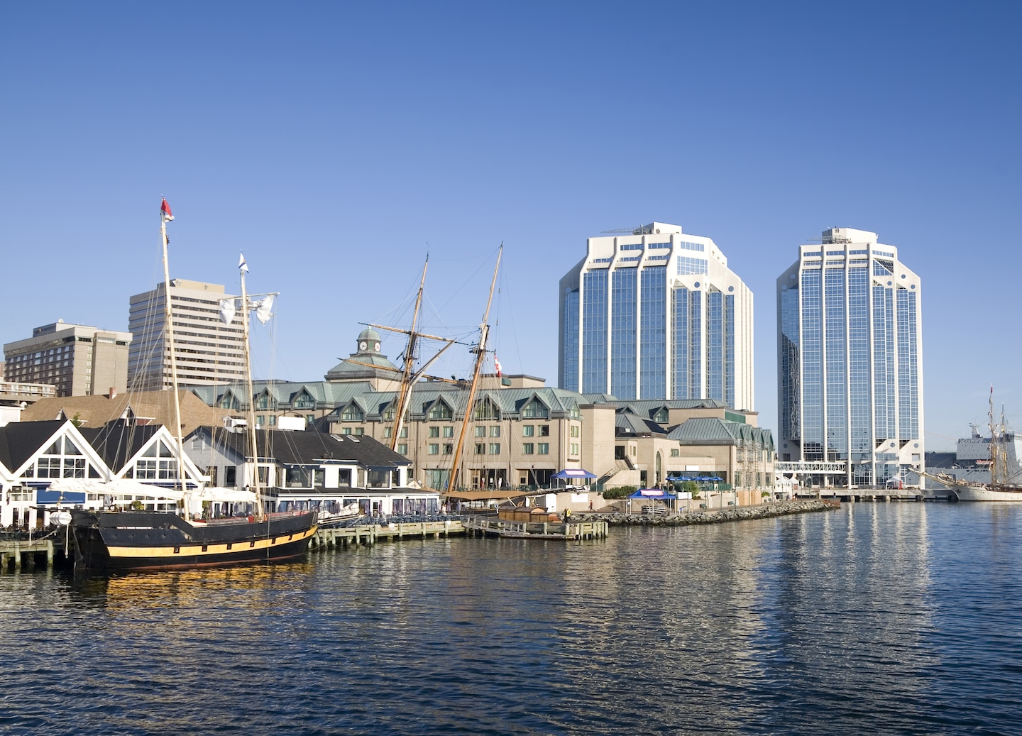 Halifax’s harbor skyline features colorful waterfront buildings set against bright blue skies and calm water. - Halifax, Nova Scotia