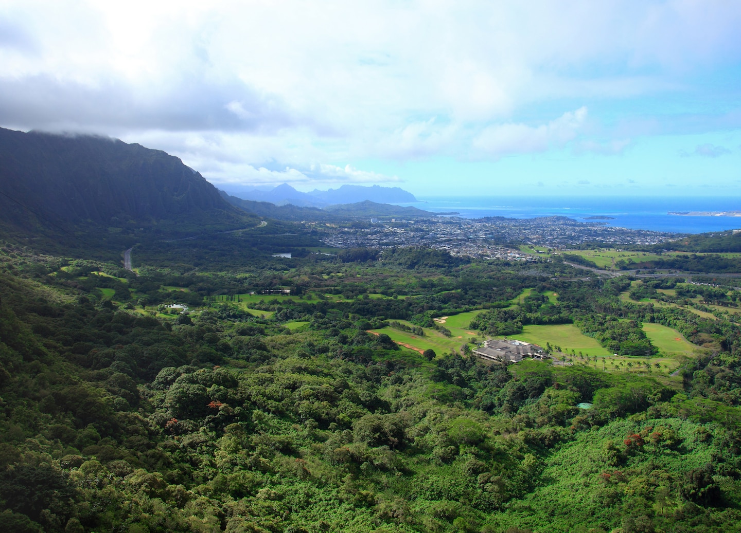 Windy cliffs at the Nu‘uanu Pali Lookout overlook lush valleys and the distant coastline. - Honolulu, Oahu, Hawaii
