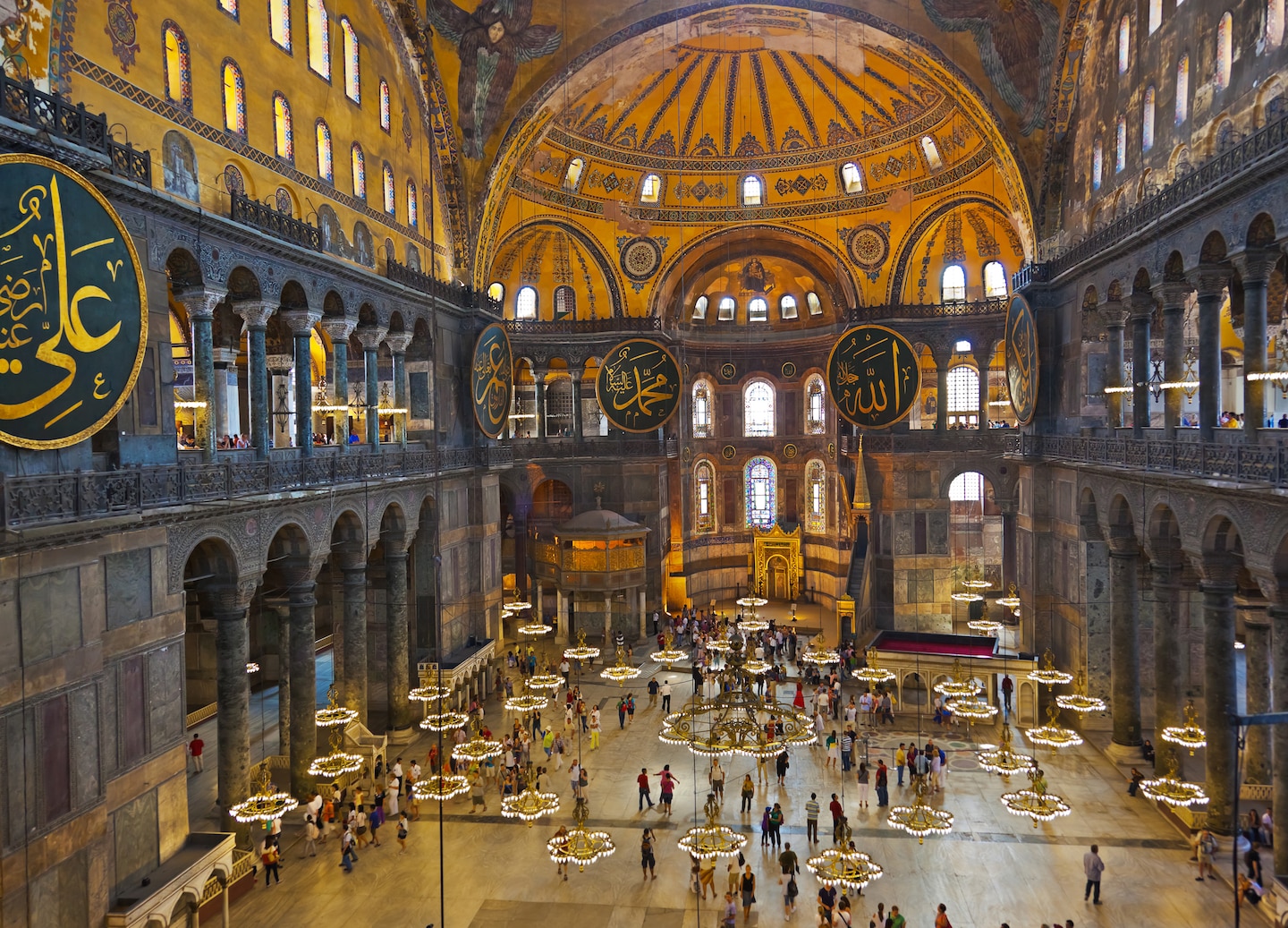 Soft golden light fills Hagia Sophia’s vast interior, highlighting arches, mosaics, and soaring domes. - Istanbul, Turkey
