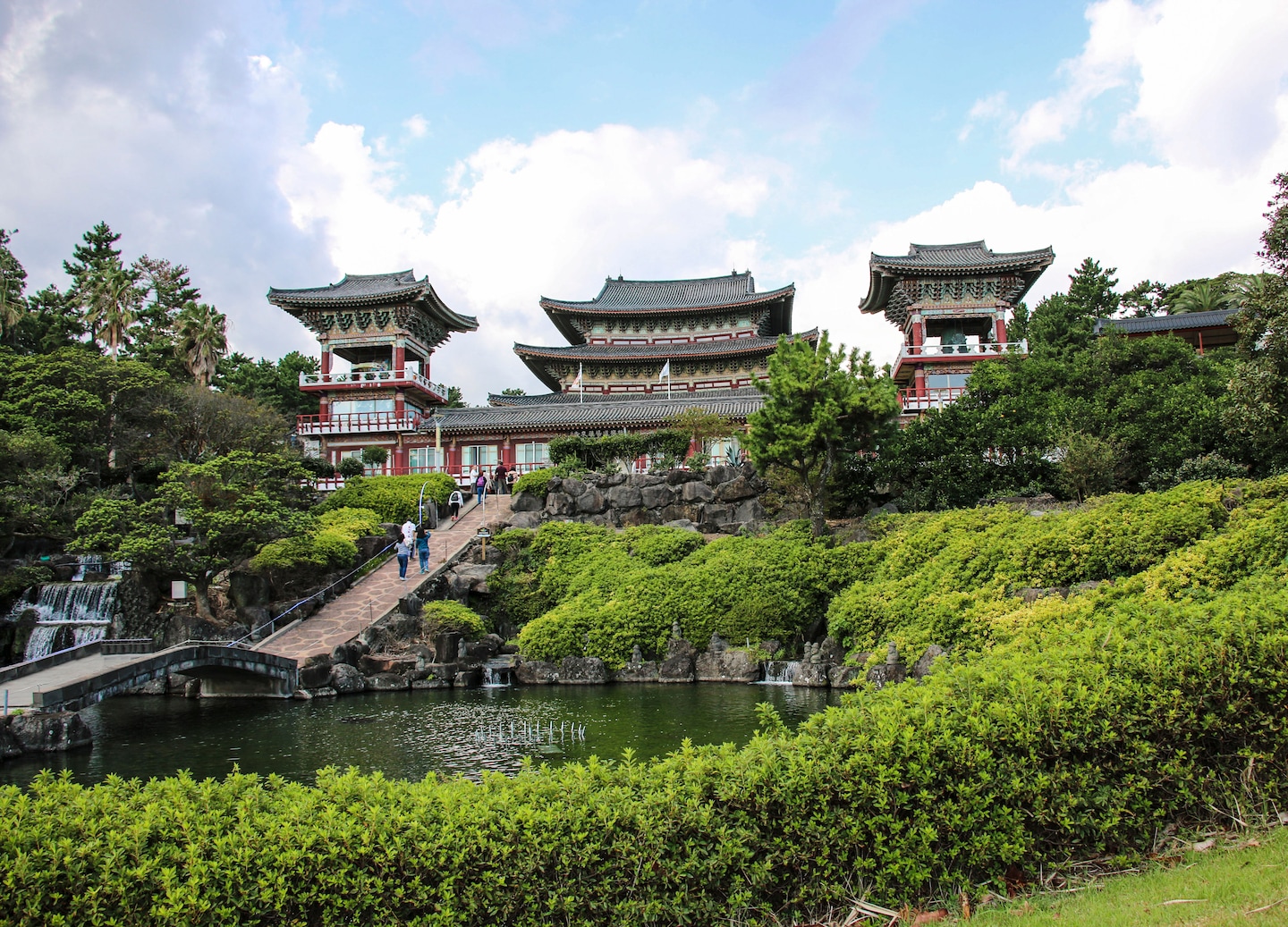 Large Yakcheonsa Temple with ornate roofs and palm trees. - Jeju, South Korea