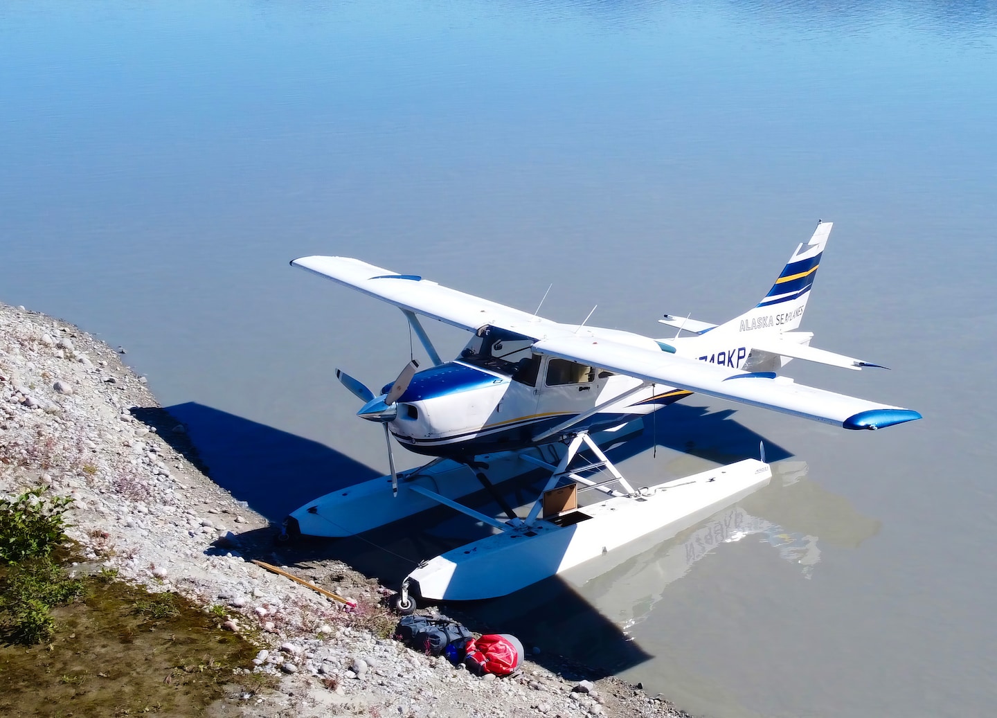 Bush plane rests beside icy Norris Glacier. - Juneau, Alaska