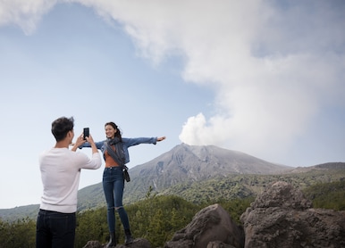 couple taking pictures infront of sakurajima volcano observatory