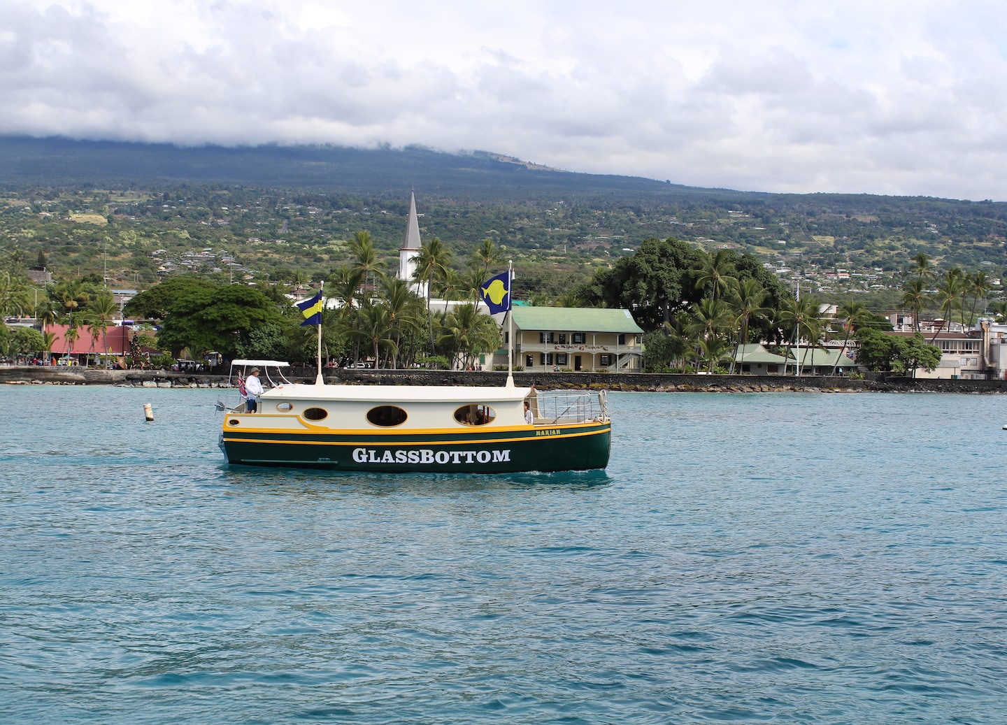 A glass‑bottom boat floats on clear Kona water, revealing colorful reef life below. - Kailua-Kona, Hawaii