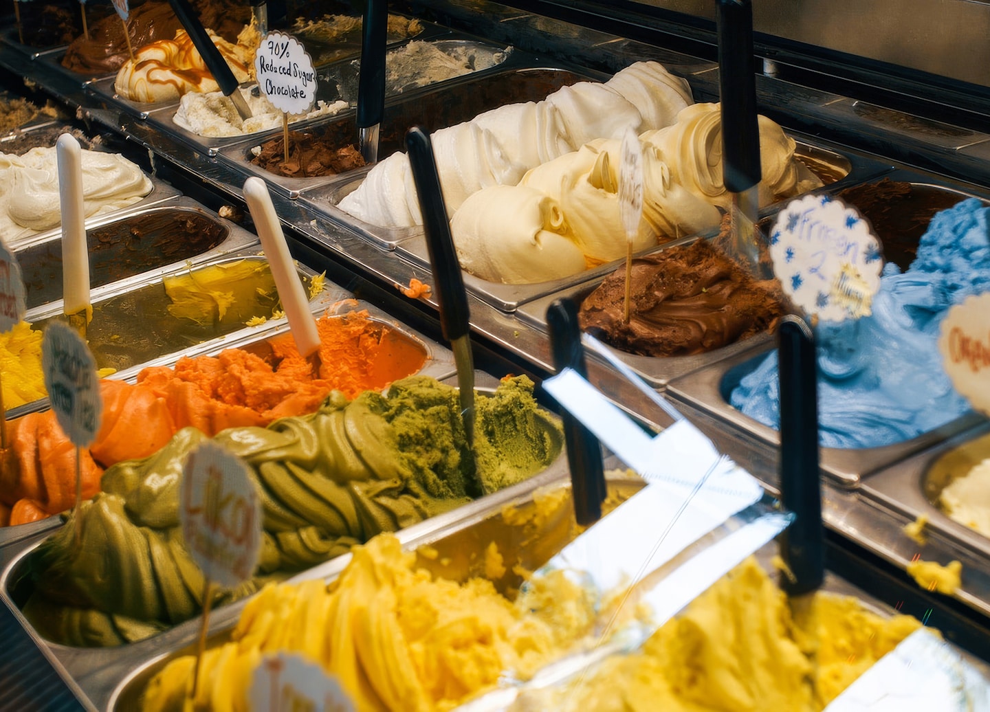 A scoop of gelato sits in a cup, topped with fruit. - Hawaii