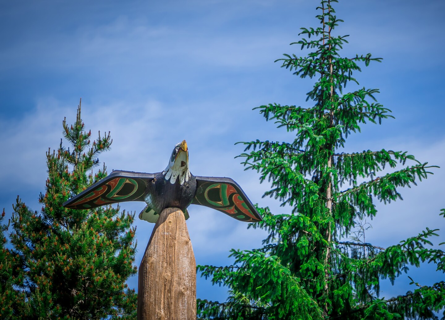 Carved totem pole featuring a bird displayed outdoors at Saxman Village. - Ketchikan, Alaska