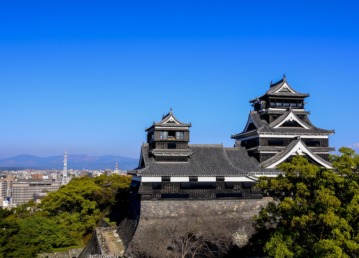 Kumamoto Castle rises above stone walls, showcasing enduring strength and historic beauty. - Kumamoto, Japan