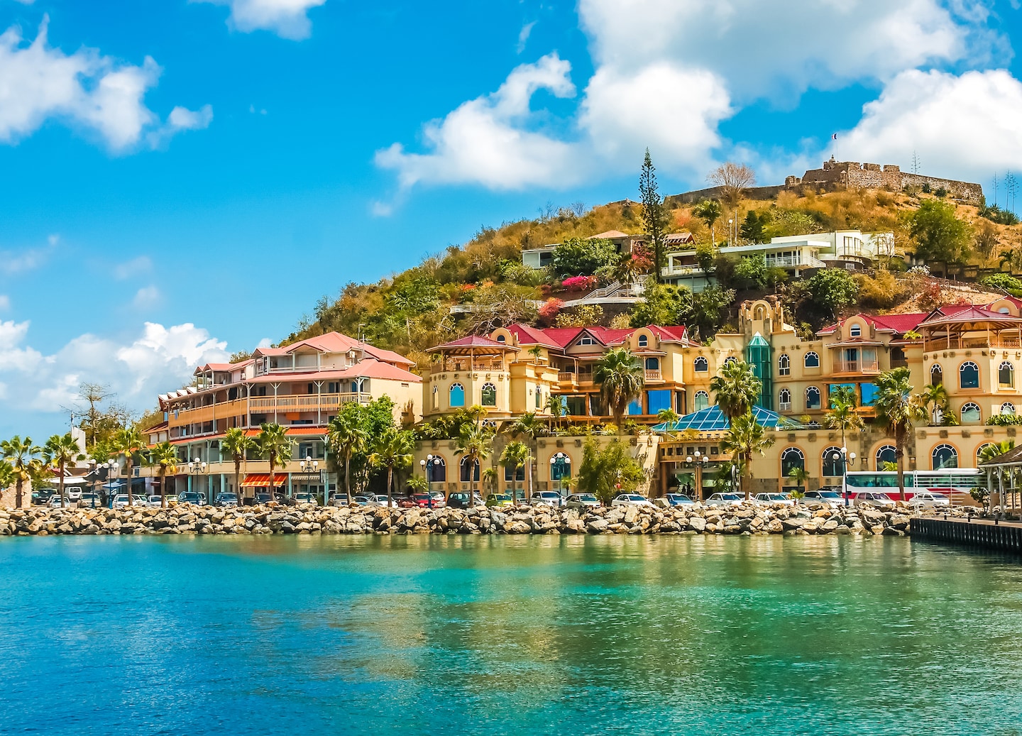 Coastal shopping street features colorful storefronts and palm trees along a sunny St. Maarten waterfront. - Philipsburg, St. Maarten