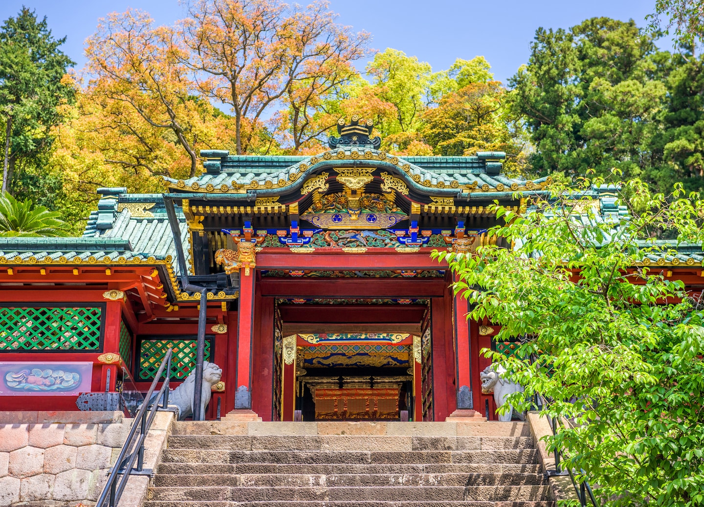 Kunozan Toshogu Shrine’s vibrant buildings sit among forested hills, with stone steps leading upward through greenery. - Mt. Fuji, Japan