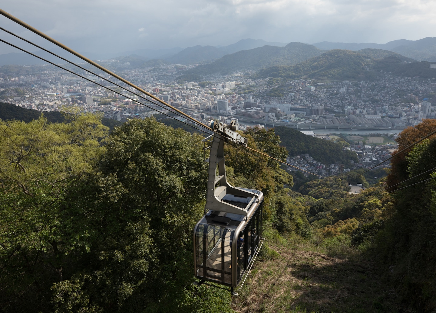 Slope car ascends Mount Inasa, revealing the Nagasaki skyline and harbor. - Nagasaki, Japan