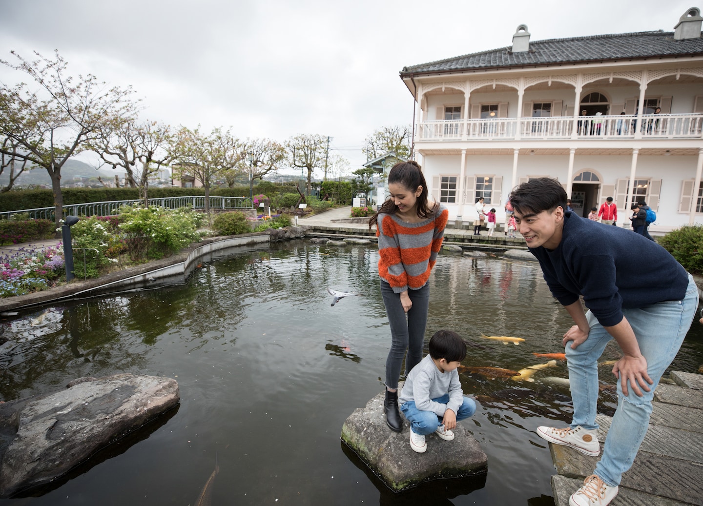 A family walks through Glover Garden’s greenery, passing historic Western‑style homes overlooking Nagasaki’s harbor. - Nagasaki, Japan
